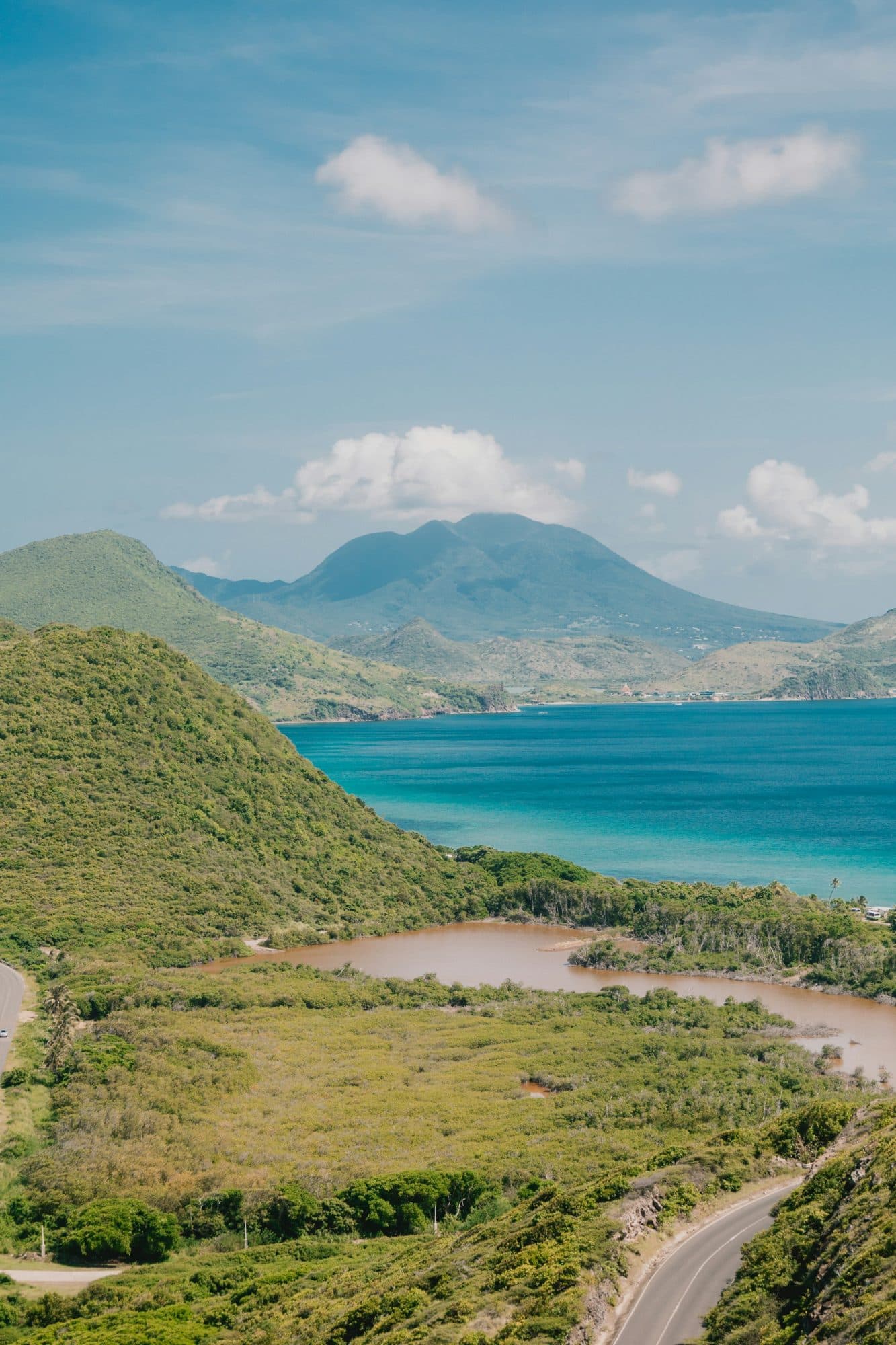 Green hills of Saint Kitts's South East Peninsula with Nevis Peak across the water